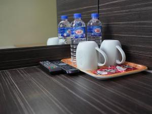 a tray with two cups and two bottles of water at Amrise Hotel, Check in at 10PM, Check out at 9AM in Singapore