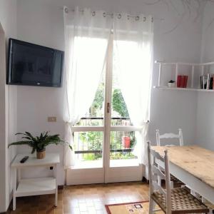 a living room with a large window and a table and a television at Appartamento Giglio in Stropino