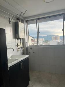 a bathroom with a sink and a large window at LA CASA DEL CABLE -Atractivo Único Sector Cable 104- in Manizales