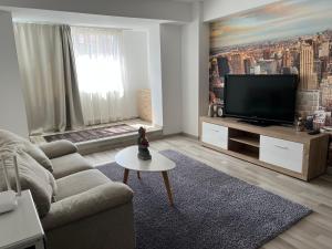 a living room with a couch and a flat screen tv at My Holiday Apartment Sibiu in Sibiu