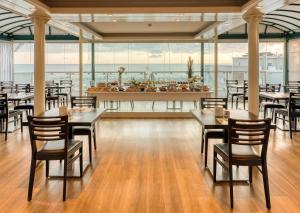 a restaurant with tables and chairs and a view of the ocean at Hotel Augustus in Rimini