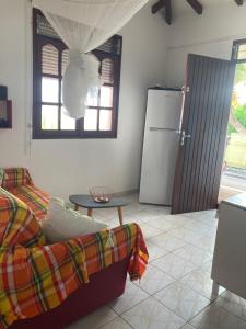 a living room with a couch and a refrigerator at Paradis Caraïbes in Sainte-Anne