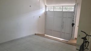 a white room with a sliding glass door at Teto Hospedagens in Fortaleza