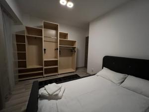 a bedroom with a large white bed and shelves at My Holiday Apartment Sibiu in Sibiu