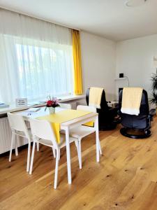 a dining room with a white table and chairs at Apartment Sonnenschein in Dornbirn