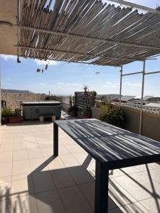 a wooden bench sitting on top of a patio at Claureece Court Mgarr in Mġarr