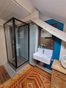 uma casa de banho com uma cabina de duche em vidro e um lavatório. em B&B Le Moulin de Fernelmont em Forville