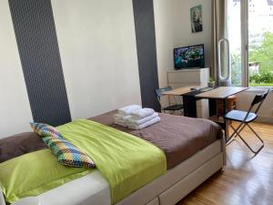 a bedroom with a bed and a desk and a television at Studio de charme in Pantin