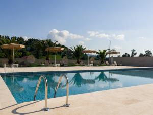 una piscina con sillas y sombrillas en Villa Elysium Park & SPA en Batumi