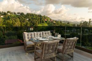 einen Tisch und Stühle auf einem Balkon mit Aussicht in der Unterkunft Villa Elysium Park & SPA in Batumi
