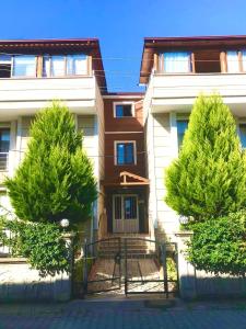 uma casa com duas árvores em frente em Удобная квартира для семьи Comfortable apartment for a family شقة مريحة لعائلة em Yalova