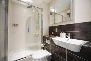 La salle de bains est pourvue d'un lavabo, d'une douche et de toilettes. dans l'établissement Cool Dalston studio with balcony and gym, à Londres