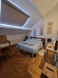 1 dormitorio con cama, mesa y sofá en B&B Le Moulin de Fernelmont, en Forville
