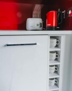 a cabinet with cups and a coffee maker on it at Cool Dalston studio with balcony and gym in London