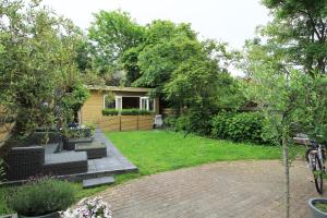 a backyard with a house with a brick patio at Appartementen aan den Hogeweg in Zandvoort