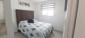 a bedroom with a bed with a quilt on it at Departamento-Poliforum Feria Estadio Zona Piel. in León
