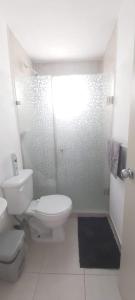 uma casa de banho branca com um WC e um chuveiro em Departamento-Poliforum Feria Estadio Zona Piel. em León