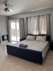 a bedroom with a large bed with a ceiling fan at Claureece Court Mgarr in Mġarr