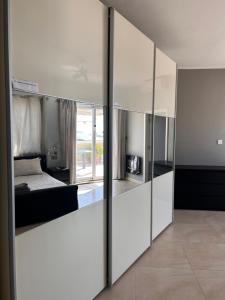 a bedroom with white walls and a bed and mirrors at Claureece Court Mgarr in Mġarr