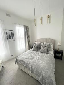 um quarto branco com uma cama grande e almofadas em Luxury Belfast Stay - Townhouse em Belfast