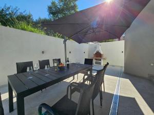 Villa Olivila في دوبروفنيك: طاولة طعام مع مظلة على الفناء