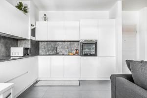 - une cuisine blanche avec des placards blancs et un canapé dans l'établissement Harmony House [Free Parking-Terrace-Netflix], à Milan