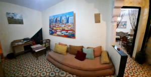 een woonkamer met een bank met kussens erop bij The Three Roses in Bhalil