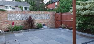 a backyard with a brick fence and a patio at 2-Bed House in Poole in Parkstone