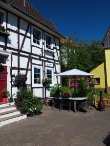 a white house with a table and an umbrella at Appartement an der Bicke in Dehringhausen