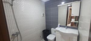 un bagno con lavandino, water e specchio di Corazón Urbano a Martil