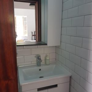 a bathroom with a sink with a mirror and a window at Sabor Residence in North Nicosia