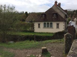 une maison blanche au milieu d'un champ dans l'établissement Maison de famille du pont Millénaire, à Ahun