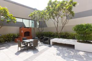 a patio with a table and chairs and trees at Hostel InterCube in Dubai