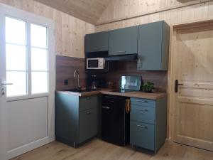 a kitchen with blue cabinets and a window at Les gîtes d'Alex 1 in Quend