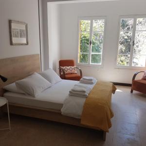 a bedroom with a bed and a chair and windows at Sabor Residence in North Nicosia