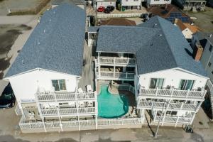 una vista aérea de una gran casa blanca con piscina en The Atlantic Motel, en Hampton