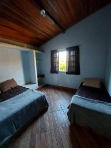 een slaapkamer met 2 bedden en een raam bij Recanto do Sossego in Caxambu