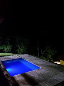 een blauw zwembad dat 's nachts op een terras zit bij Recanto do Sossego in Caxambu