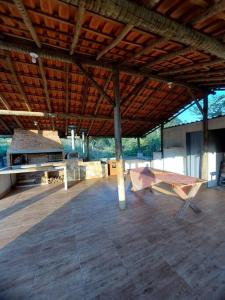 een groot paviljoen met een picknicktafel en een grill bij Recanto do Sossego in Caxambu