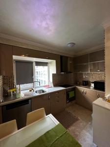 a kitchen with brown cabinets and a sink and a window at Unirii Home in Bucharest