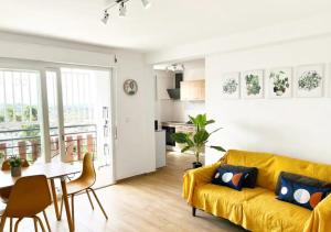 uma sala de estar com um sofá amarelo e uma mesa em 42m2 neuf centre ville avec parking, balcon et sans coupure d'eau em Mamoudzou