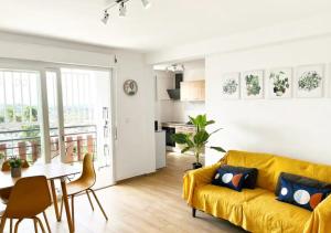 a living room with a yellow couch and a table at 42m2 neuf centre ville avec parking, balcon et sans coupure d'eau in Mamoudzou