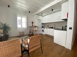 una cucina con armadi bianchi, tavolo e sedie di Grândola Suites - Suite Loft a Grândola