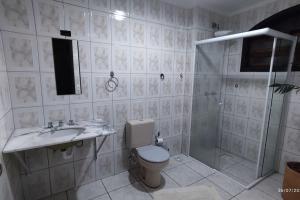 a bathroom with a toilet and a sink and a shower at Oberon in Curitiba