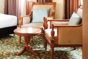 - un salon avec une chaise et une table dans l'établissement Western Suites Hotel, à Tachkent