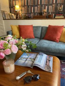 a coffee table with a book and glasses and a couch at Hotel Le Trouville in Trouville-sur-Mer