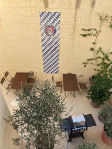 a flag on a wall with chairs and a grill at The White Knight Premium Boutique Hotel in Għajnsielem
