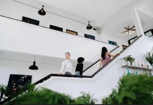 tres personas sentadas en las escaleras de una casa en The Courtyard Chiangrai, en Chiang Rai