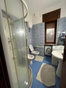 La salle de bains est pourvue de 2 toilettes et d'une douche en verre. dans l'établissement GrannyHome, à SantʼArpino