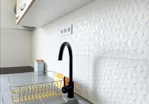uma cozinha com um lavatório e uma torneira em 42m2 neuf centre ville avec parking, balcon et sans coupure d'eau em Mamoudzou